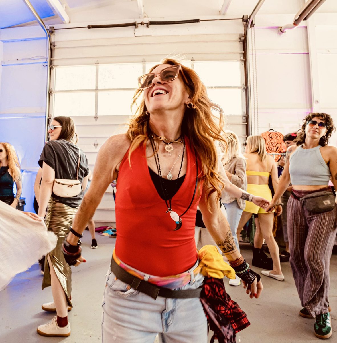 Michelle laughing mid-dance in a room full of people moving